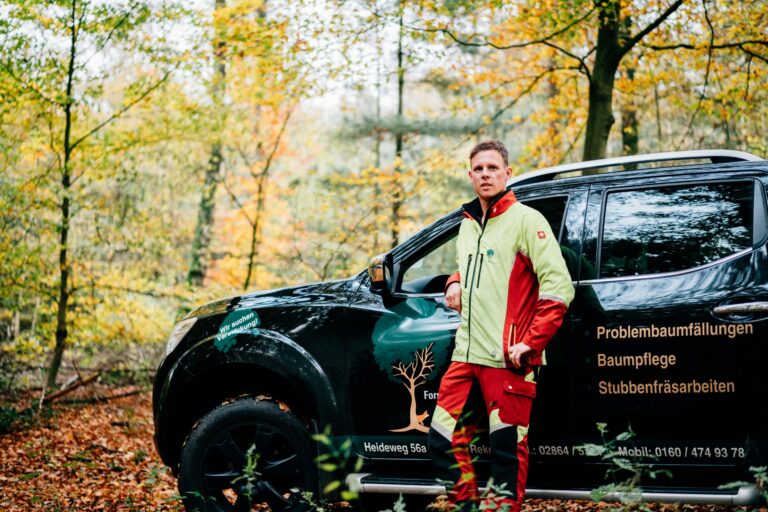 Jan Pels steht in Wald vor seinem Jeep